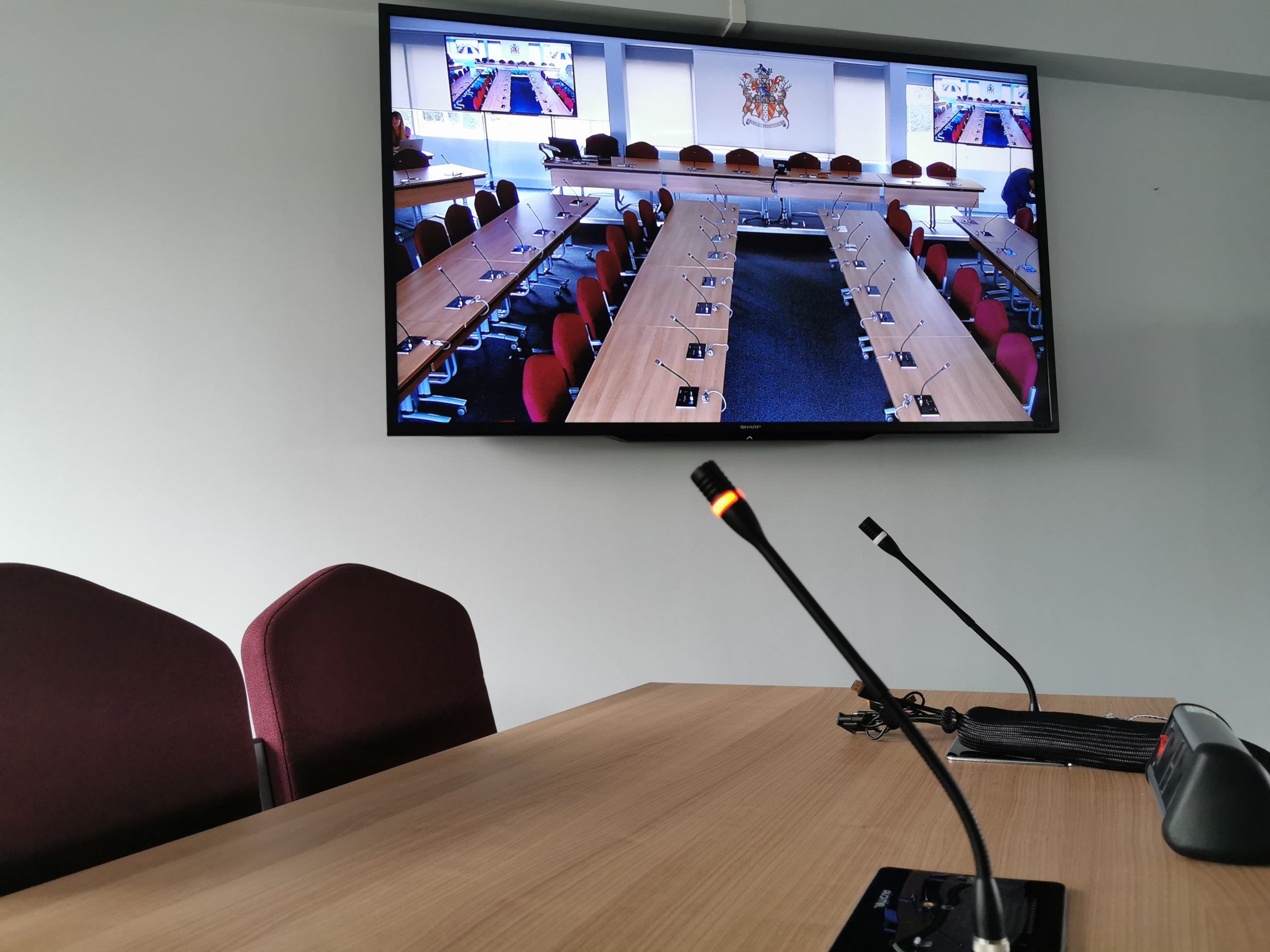 conference microphones and tv screen with live broadcast
